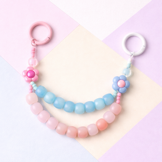 Pastel-colored beaded keychains on a colorful geometric background