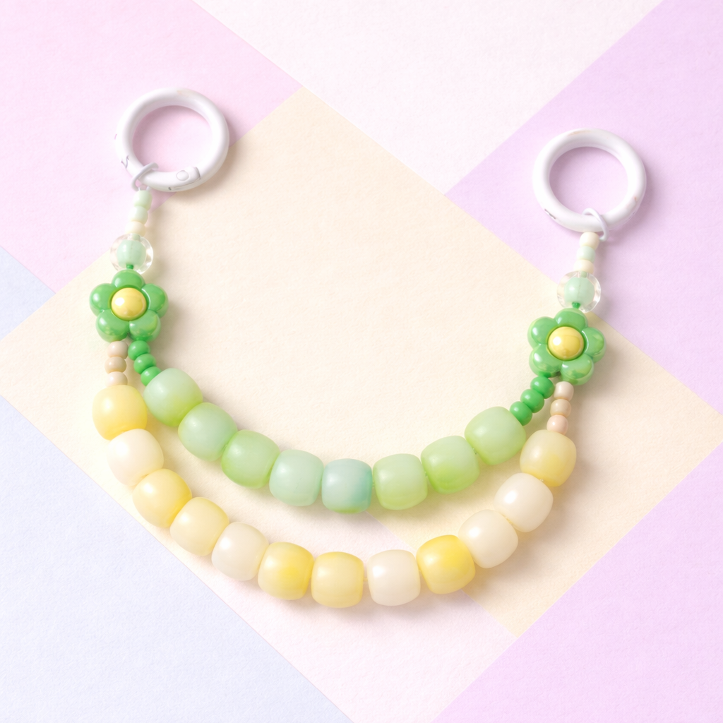 Pastel-colored beaded keychain on a colorful geometric background