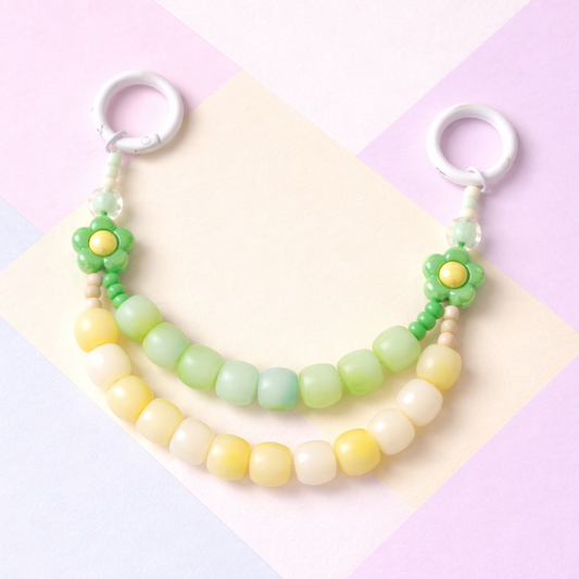 Pastel-colored beaded keychain on a colorful geometric background