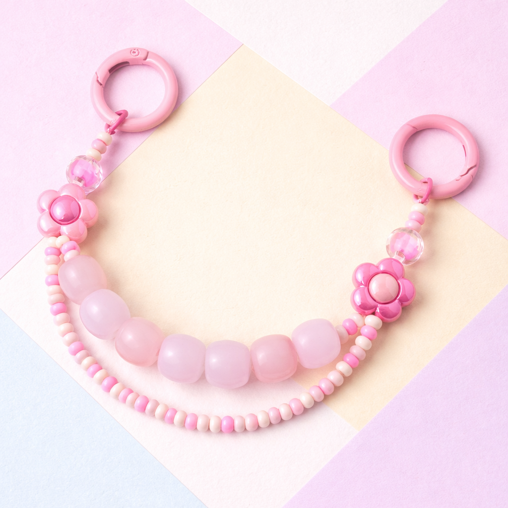 Pink beaded necklace with floral design on a colorful geometric background