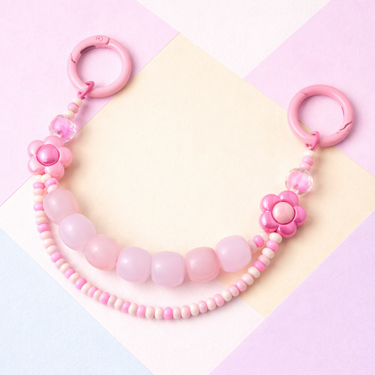 Pink beaded necklace with floral design on a colorful geometric background