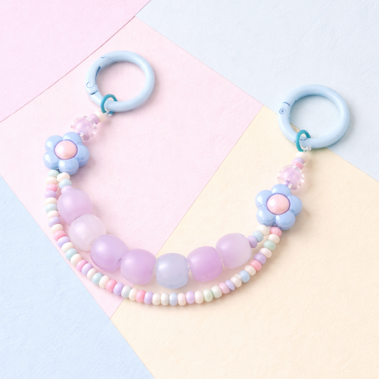 Pastel-colored beaded necklace with floral designs on a colorful geometric background