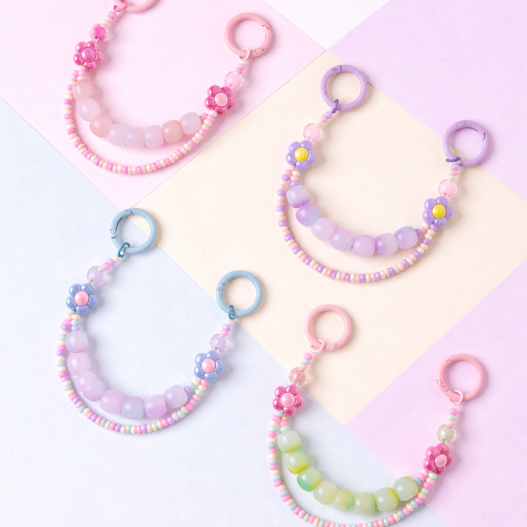 Set of colorful beaded keychains on a pink and white background