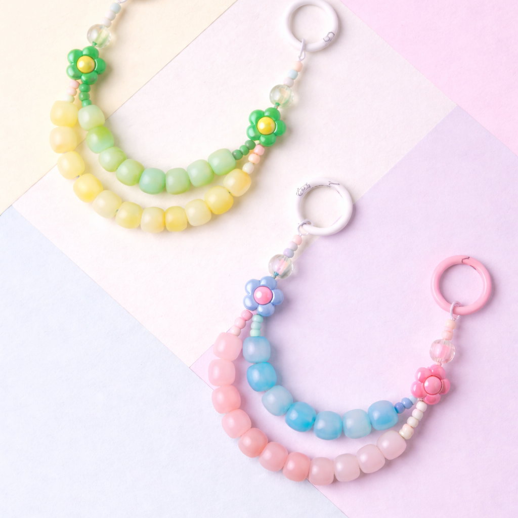 Two colorful beaded keychains on a pastel background