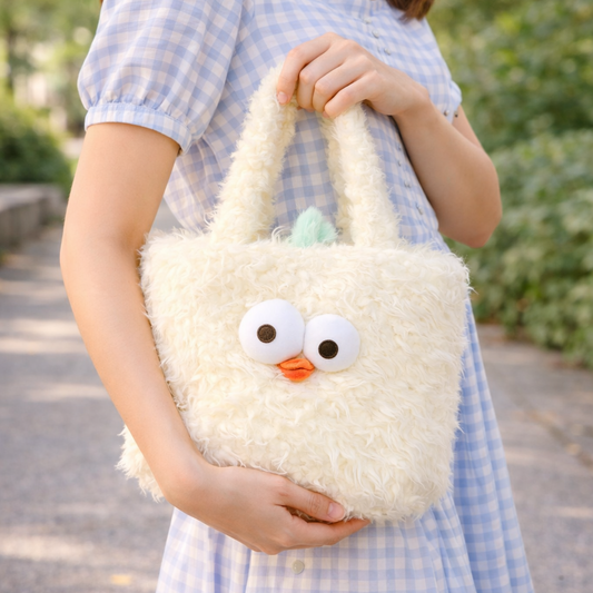 Person holding a fluffy white bag shaped like a cartoon character outdoors.