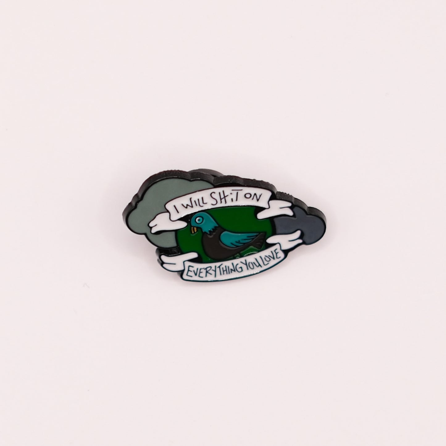 Enamel pin with a cartoon pigeon and text on a white background