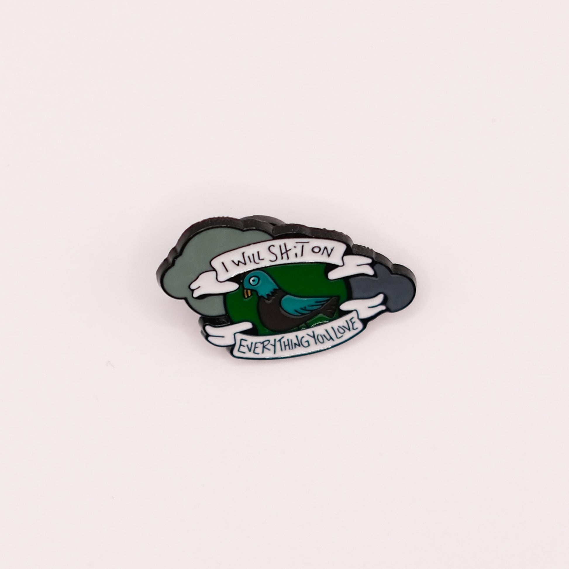 Enamel pin with a cartoon pigeon and text on a white background