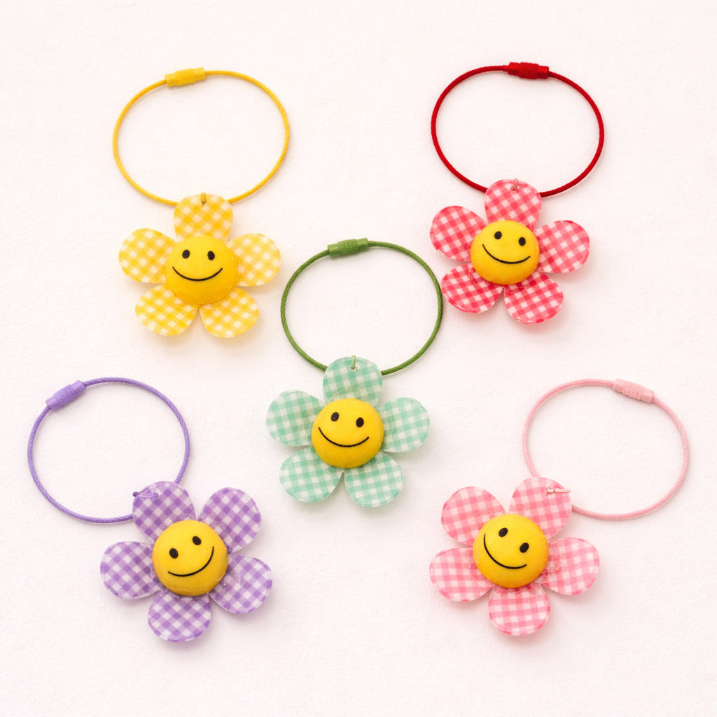 Colorful hair ties with smiley face designs on a white background