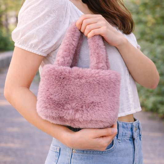 Person holding a pink fluffy bag outdoors